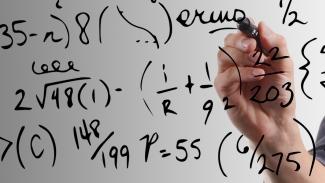 Math formulas are written on a glass wall. 