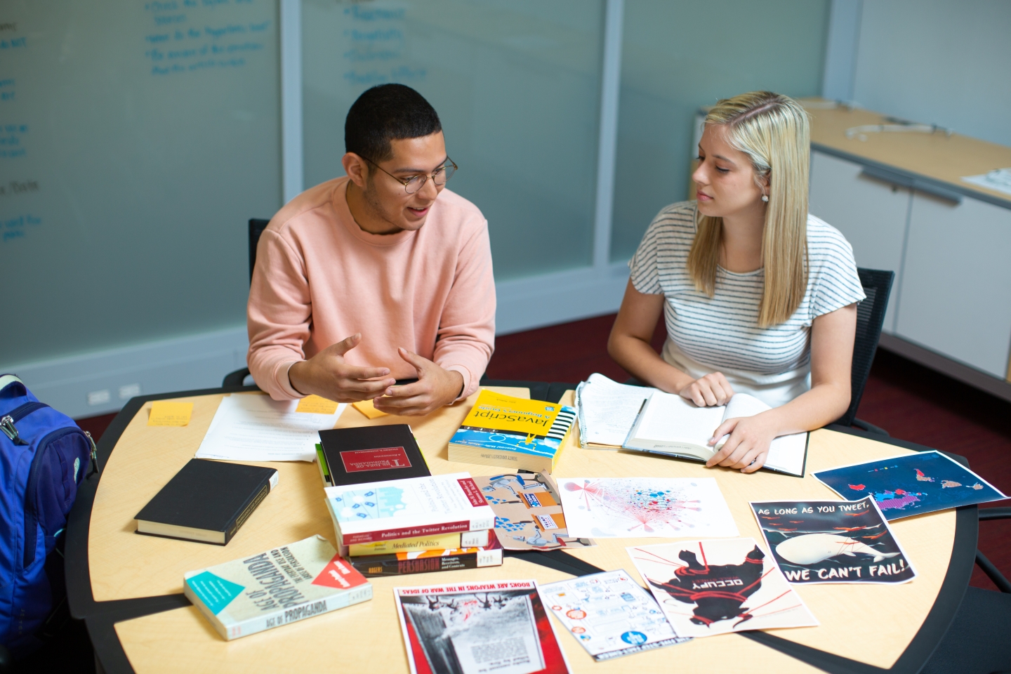 Students around a table with books and work projects