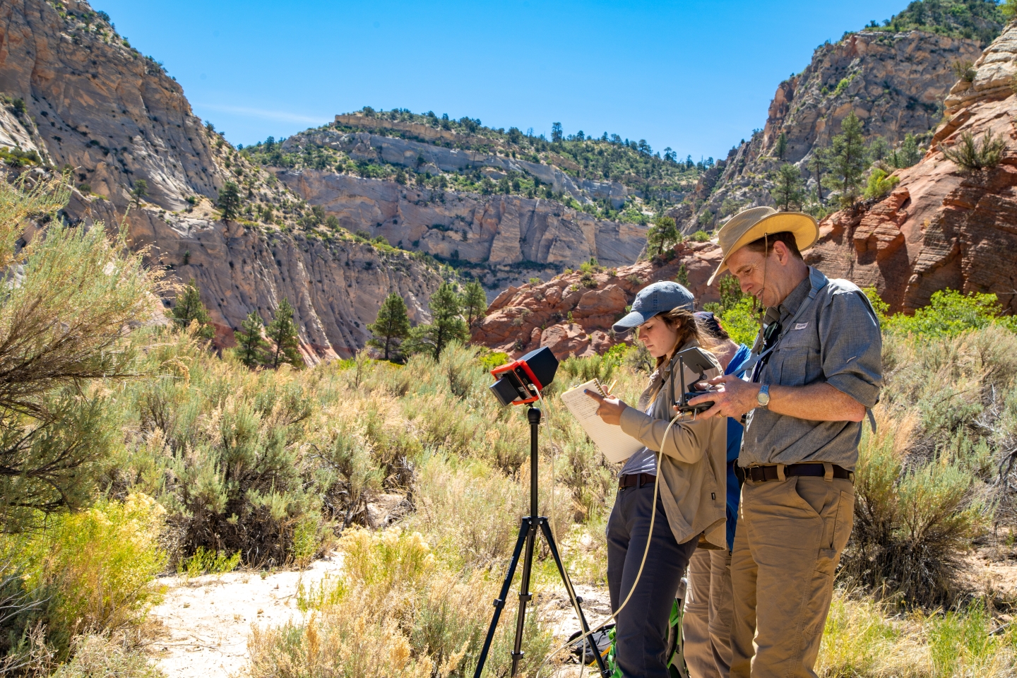 Professor and students taking measurements in canyon