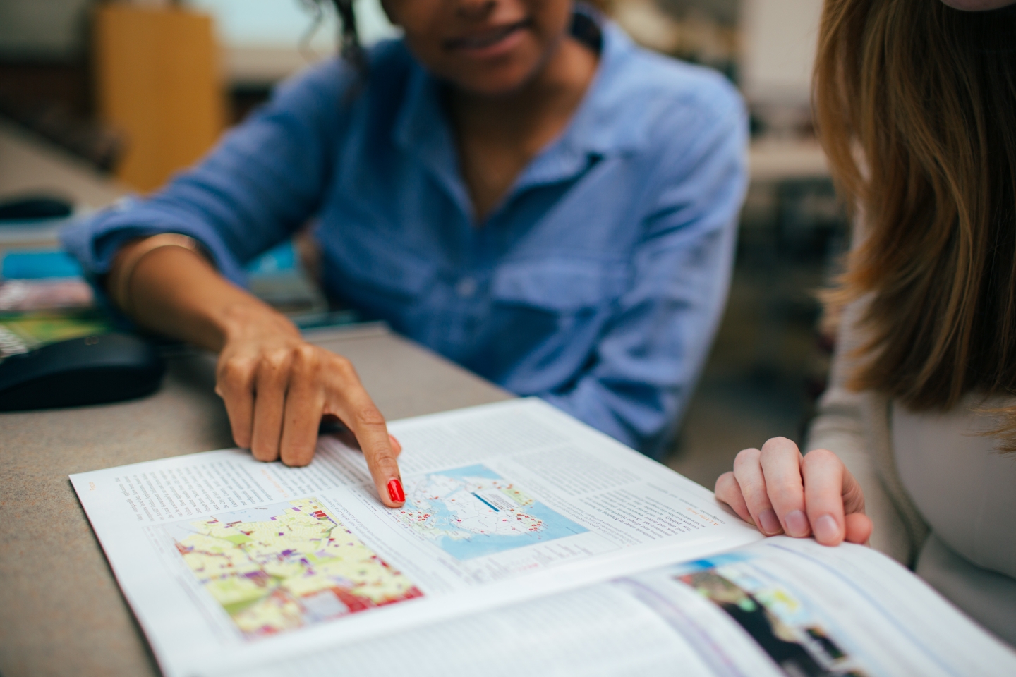 Student pointing at map in a magazine 