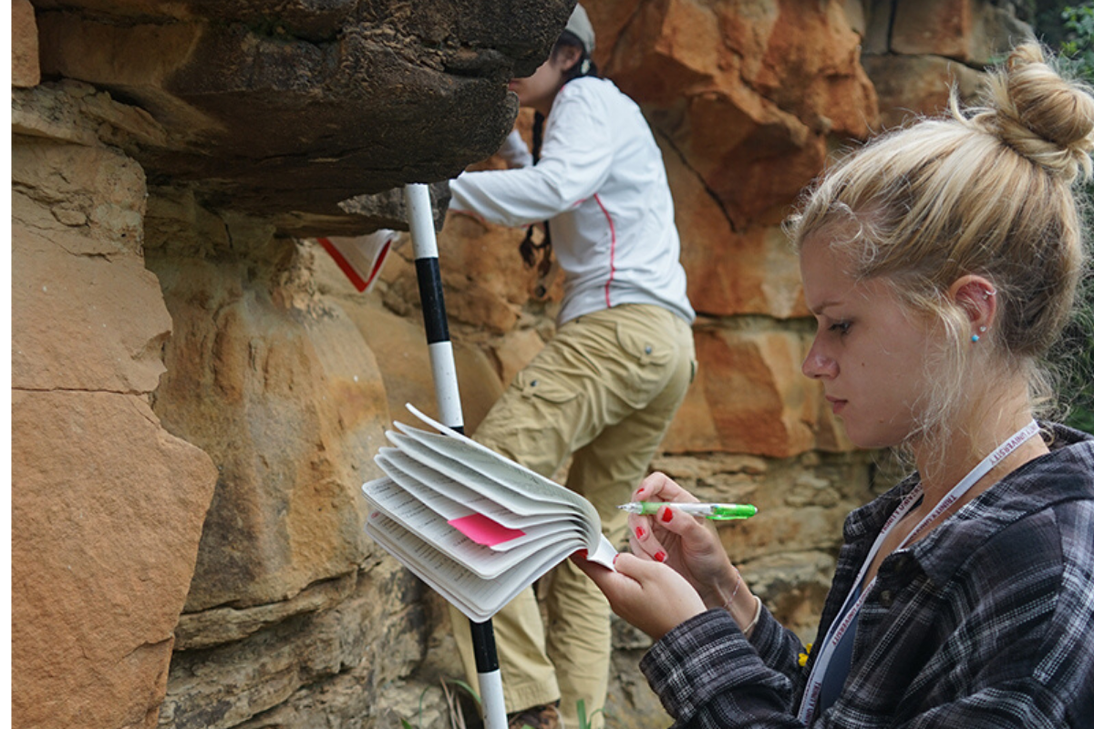 Student Studying A Rock In Nature