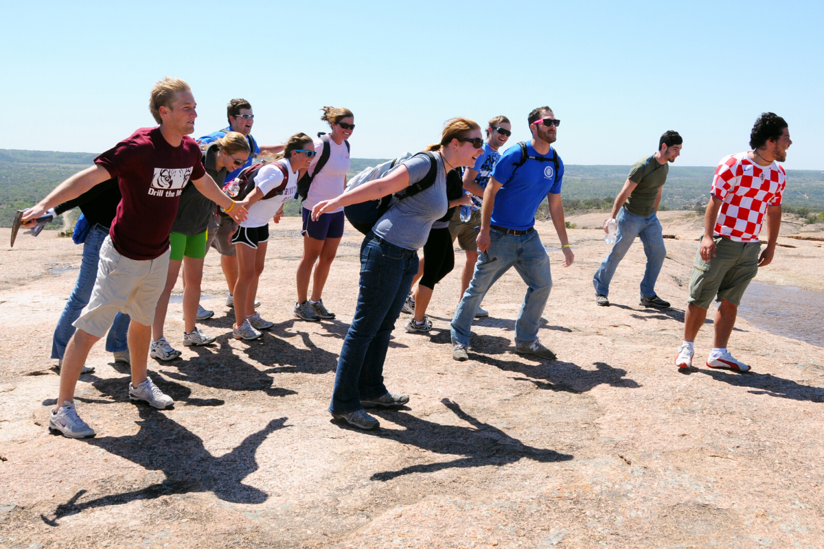 Professor and Students Leaning Towards The Wind