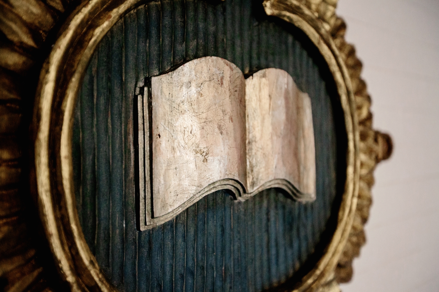 A book open in a circular gold frame