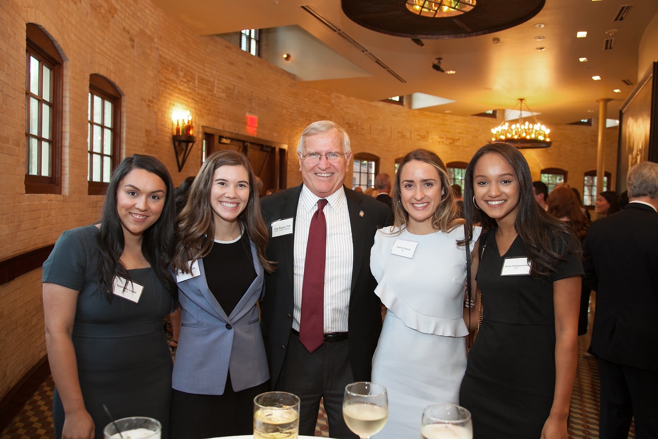 Four female graduate students gather with their professor at the Alumni Dinner.