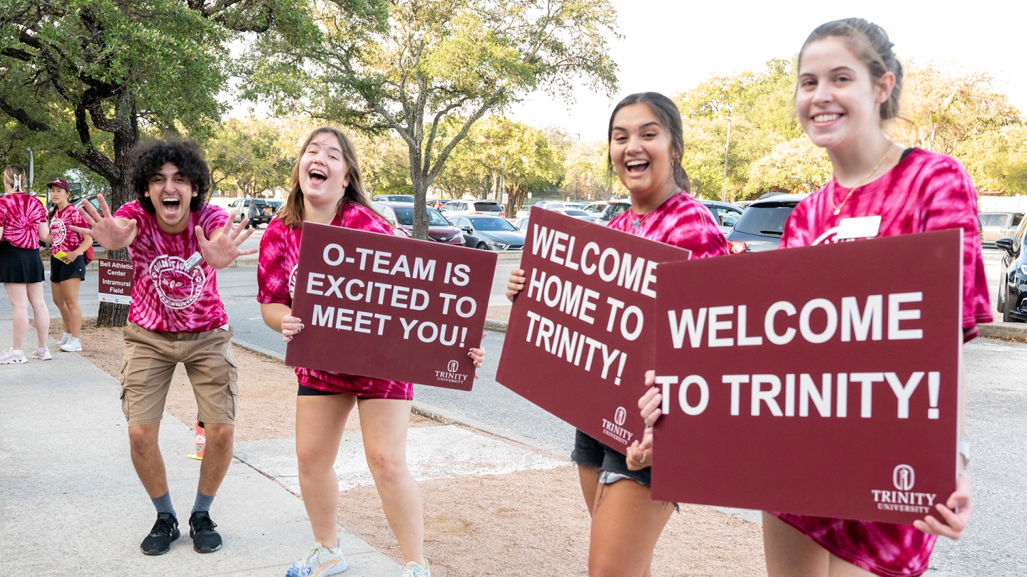 Students holding up sings welcoming new students to campus.