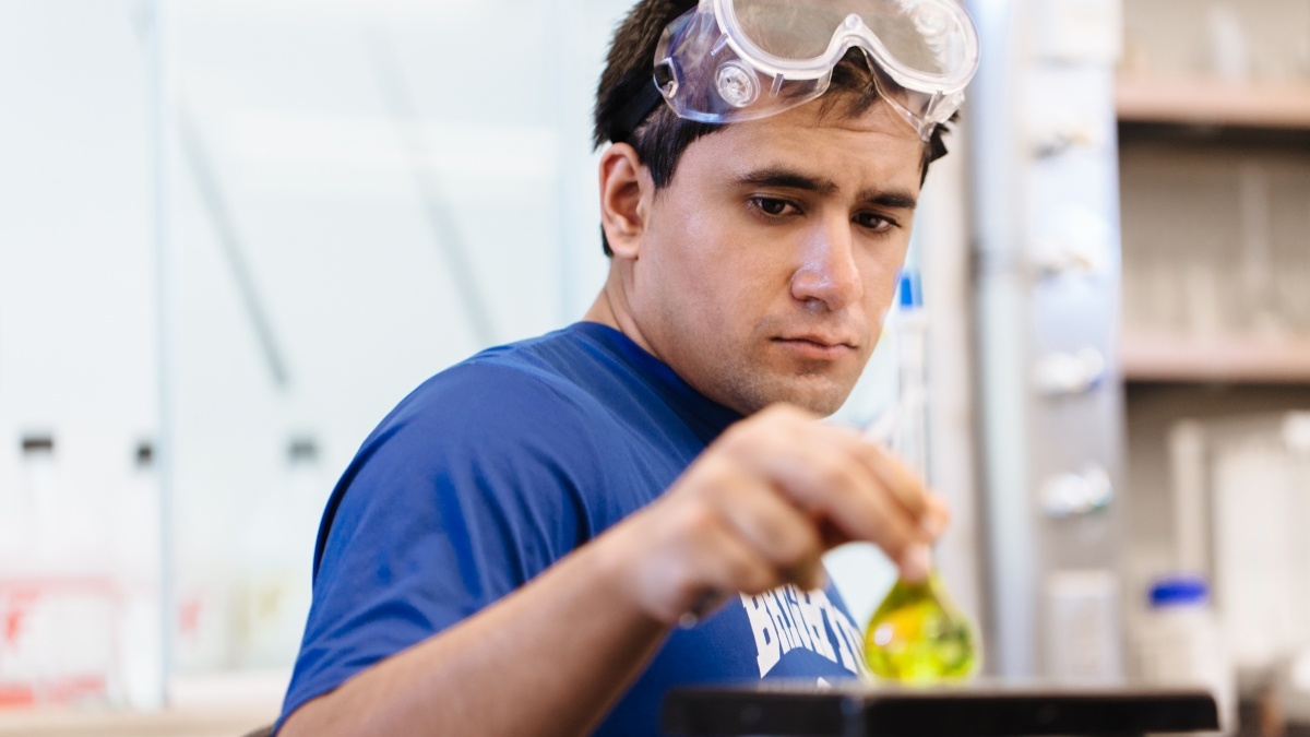 Student looking at yellow fluid in test tube