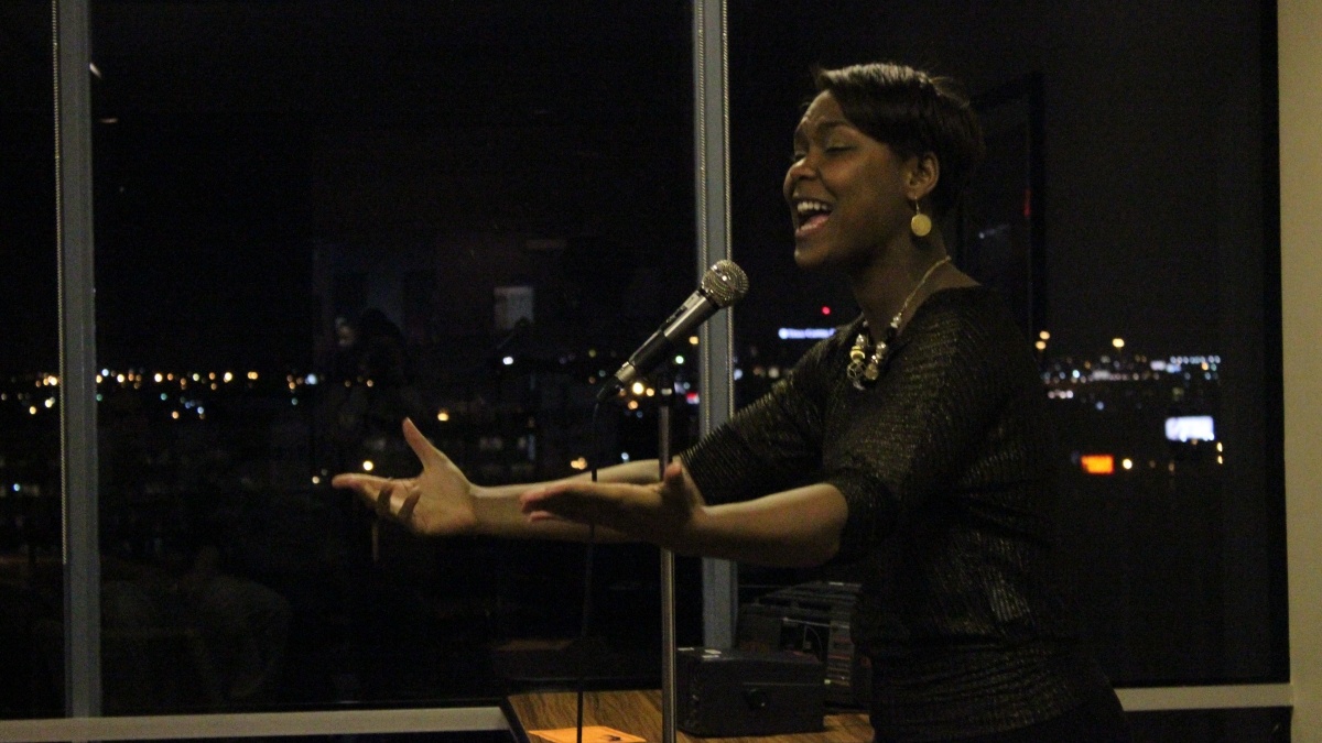 African American woman reading a poem at mic night