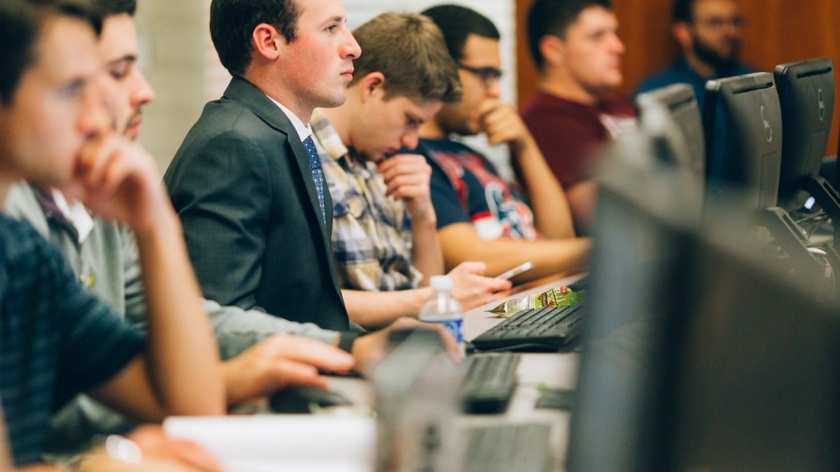 Students sit in a row in one of the Trinity computer labs