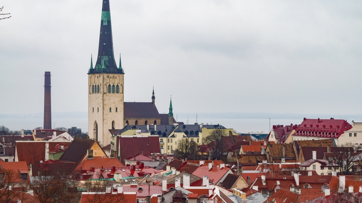 The spire of St. Olav's Church in Tallinn, Estonia towers over the town buildings 