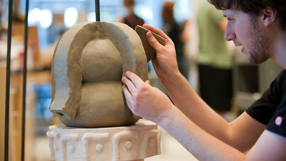male student working on a sculpture