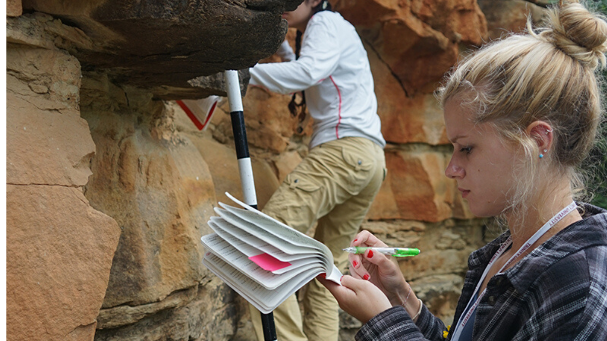 Student Studying A Rock In Nature