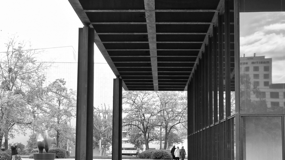A person walks through a covered space on a mid-century building