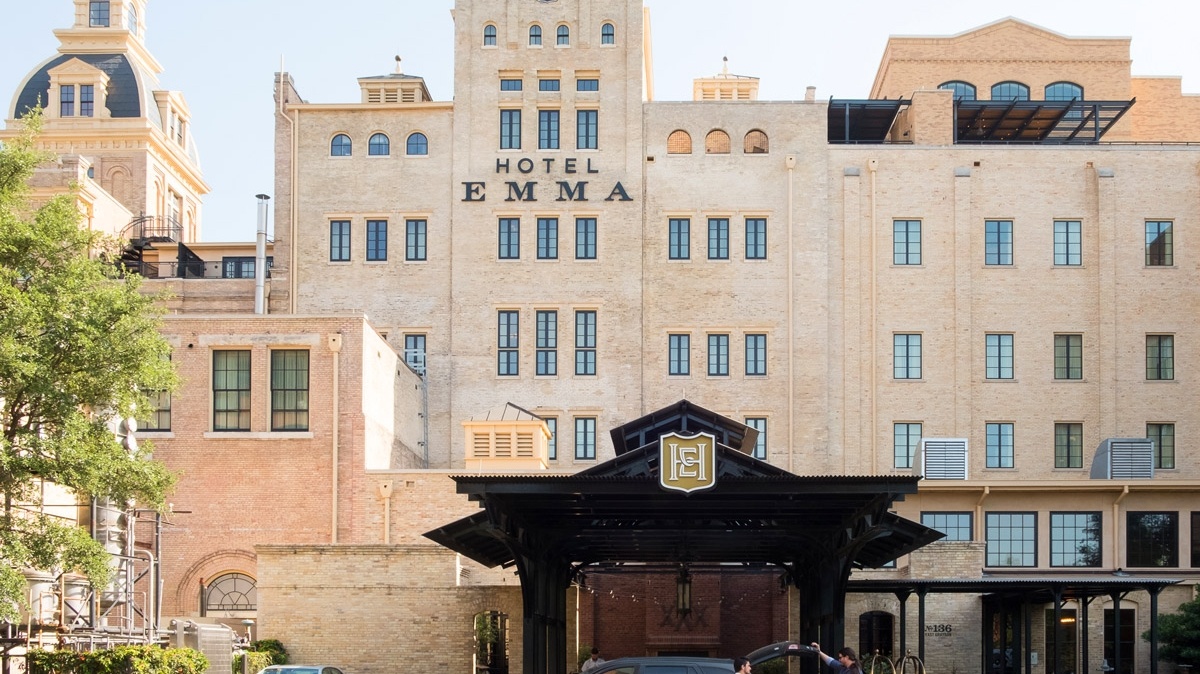 the Hotel Emma from the riverwalk; a man is unloading his car