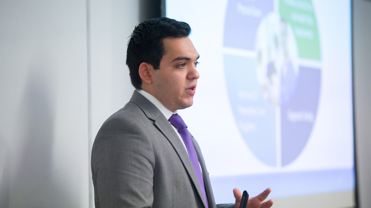 Graduate student presents a business plan in a classroom.