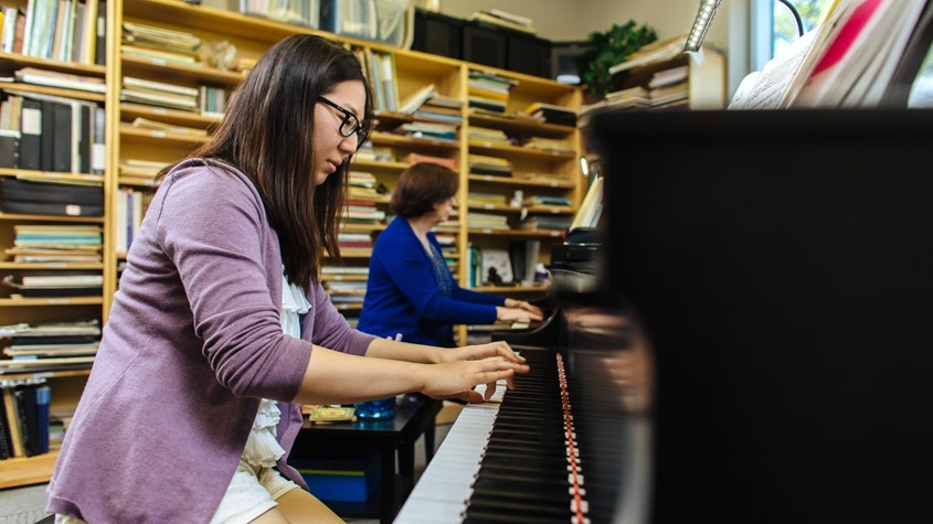 Music student and Trinity professor practice on the Steinway Concert Grand piano