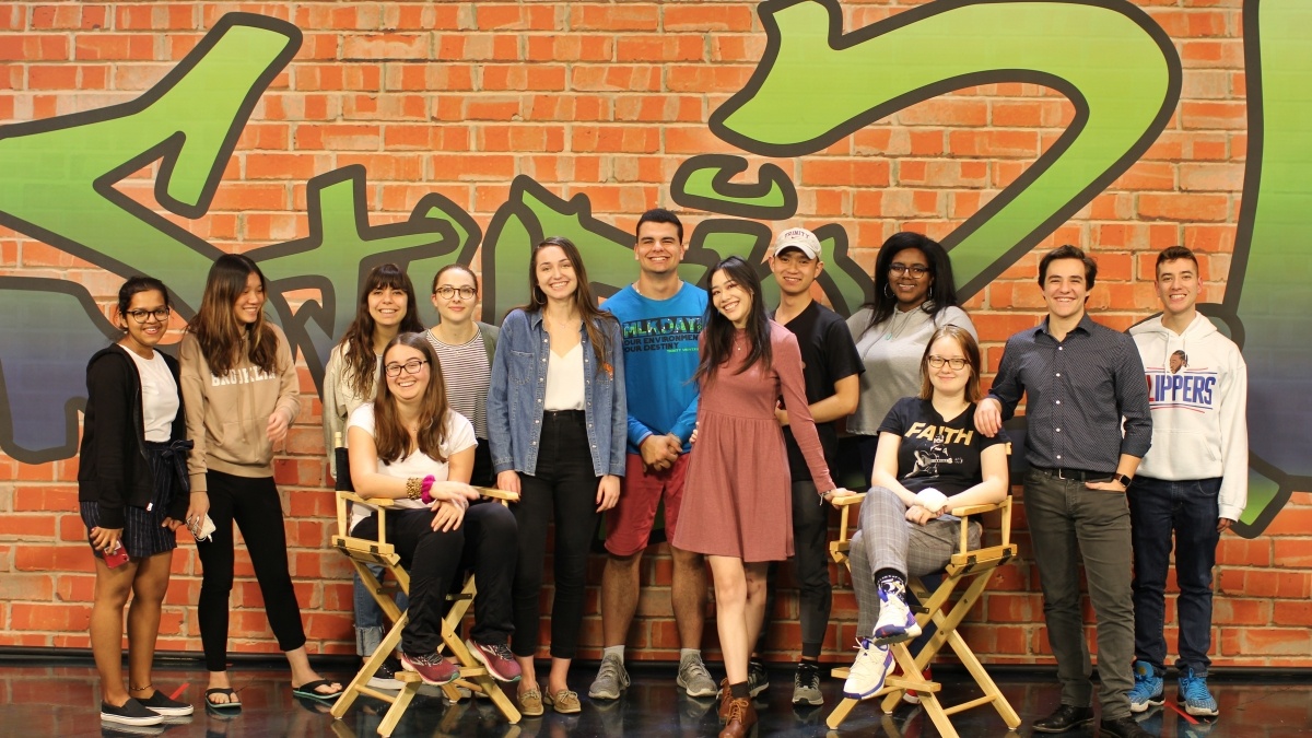 Group of students in front of the Studio 21 wall
